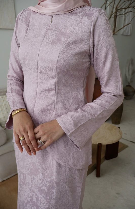 Person wearing a light purple lace outfit indoors.